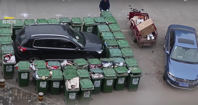В Китайской республике мусорщик заблокировал неправильно припаркованную машину баками